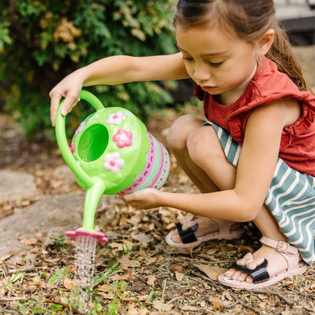 Girl watering plants with Melissa & Doug Pretty Petals Watering Can